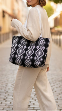 A black tote bag with a white and gray geometric pattern