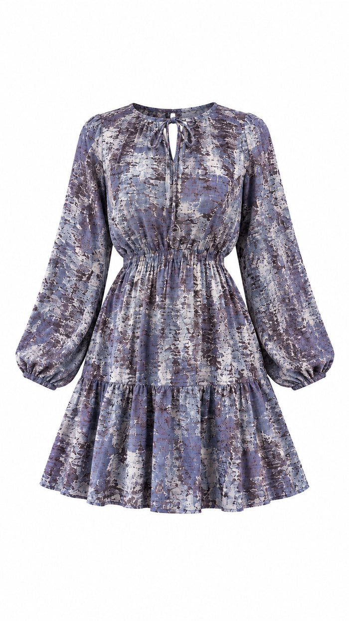 A long-sleeve tiered mini dress with a purple and gray abstract pattern with elastic waistband 